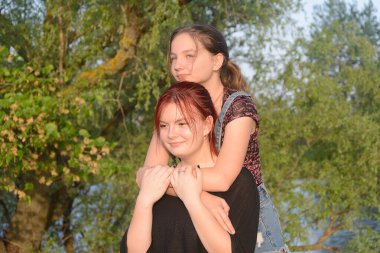 İki genç kız kardeş birbirlerine sarılıyorlar. Aile içinde aşk.