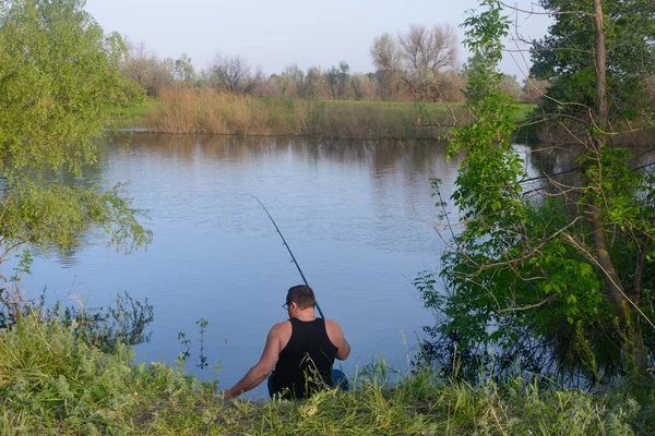 Pescador Senta Com Vara Pesca Margem Rio Vista Trás — Fotografia de Stock