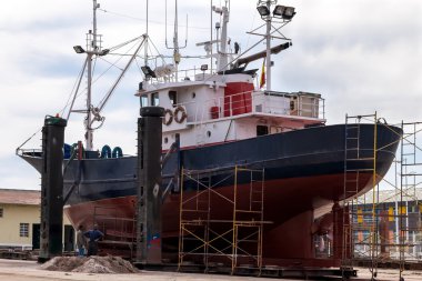 Fishing boat in a shipyard for maintenance clipart