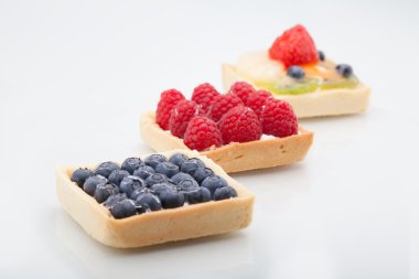 Çapraz ile çilek, raspbe dizilmiş üç kare kek