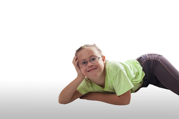 Lying horizontally girl with glasses in gray jeans — Stock Photo, Image