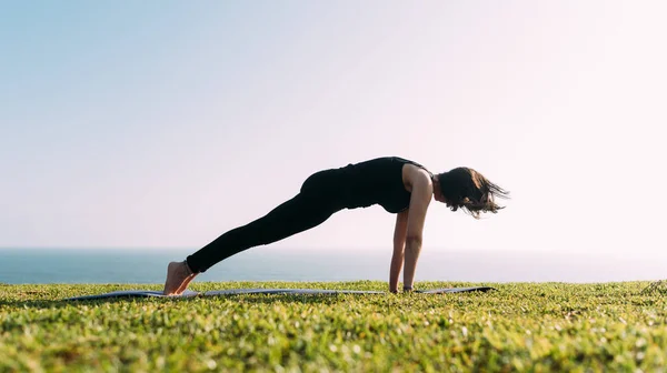 Zayıf bir kadın dışarıda yoga yapıyor. Boşluğu kopyala