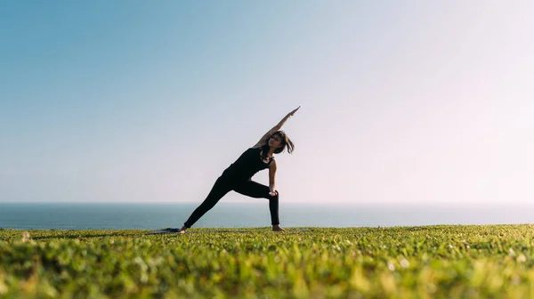 Sıska kadın doğal ortamında yoga yapıyor. Boşluğu kopyala