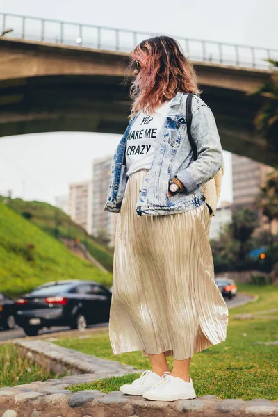 Modaya uygun giyinmiş, arka planda köprüsü olan bir feminist. Dikey resim