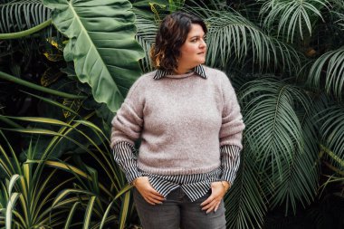 woman posing with a foliage background