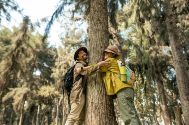 Çok ırklı bir çift gün boyunca ormanda bir ağaca sarılır.