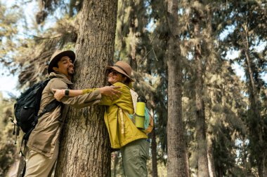 Çok ırklı bir çift gün boyunca ormanda bir ağaca sarılır.
