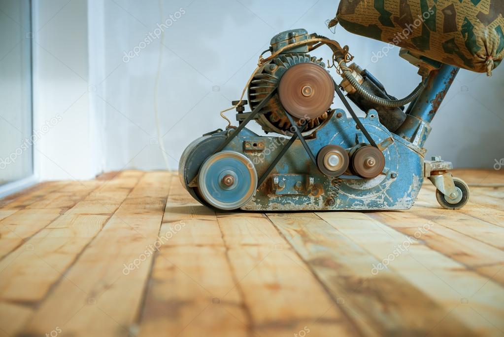 Worker polishing parquet floor with grinding machine — Stock Photo