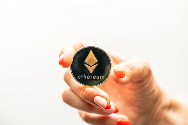 Golden Ethereum in a woman hand, Digital symbol of a new virtual currency.