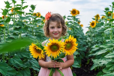 Ayçiçeği ile genç gülümseyen kız