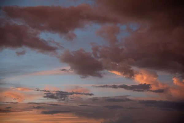 Schöner Himmelshintergrund. Hellblauer Himmel mit dramatischen orangen, rosa und grauen Wolken. — Stockfoto