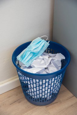 Mavi bir kutuda cerrahi maske kullanılmış. Corona Covid-19 virüs salgınında kullanılan maskeler atıldı..