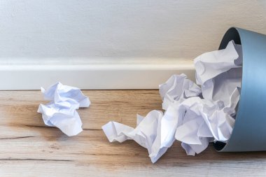 Paper trash. crumple paper falling to the recycling bin, Was thrown to basket bin, Overflowing waste paper in office garbage bin old wooden background side view with copy space
