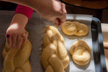 Ev yapımı challah ekmeği pişirmek. Pişirmeden önce tavada susam tohumları olan örgü.