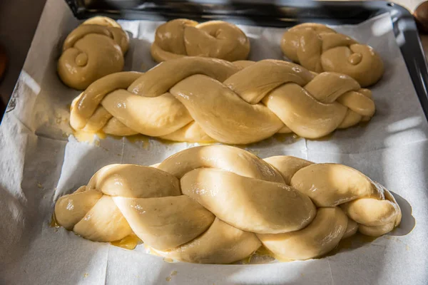 Piekę domowej roboty chleb chałki. Warkocz z nasionami sezamu na patelni przed pieczeniem — Zdjęcie stockowe
