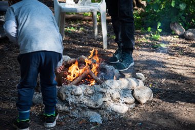 Sıcak kömürde fırında patates pişirmek. Piknikteki şenlik ateşinde folyonun içinde lezzetli sebzeler gömülüydü. Dışarıda vejetaryen yemeği. Kızarmış patatesler ateşte, barbekü. Ormanda yemek, akşam yemeği.