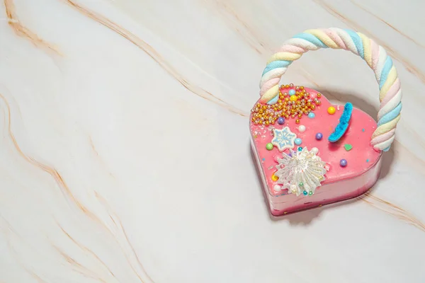Pastel en forma de corazón rosa sobre un fondo de mármol blanco con una gran cantidad de pequeños caramelos de colores. San Valentín. Sobre el amor. espacio de copia —  Fotos de Stock