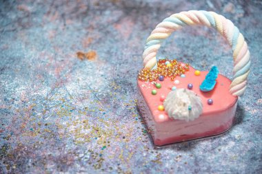  Mavi mermer arka planda pembe kalp şeklinde kek ve bir sürü küçük renkli şeker. Sevgililer Günü. Aşk hakkında. Boşluğu kopyala