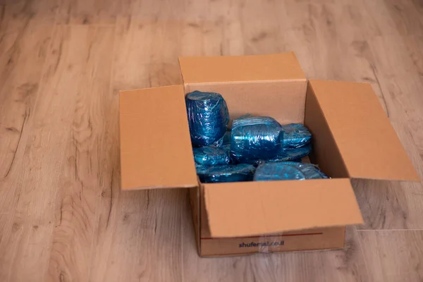 Glassware wrapped with blue wrapping nylon at the bottom of a cardboard box. Glassware wrapped in a box — Stock Photo, Image