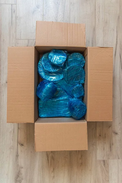 玻璃器皿，用蓝色的尼龙包裹在纸盒底部。玻璃器皿包在盒子里 — 图库照片