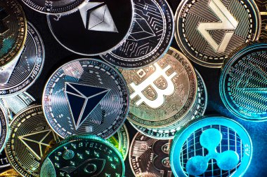 Yukarıdan siyah arka planda görülen Bitcoin, dogecoin ve ethererum gibi kripto para birimlerinin yatay görünümü