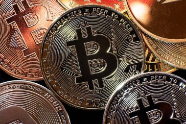 Yukarıdan siyah arka planda görülen Bitcoin, dogecoin ve ethererum gibi kripto para birimlerinin yatay görünümü