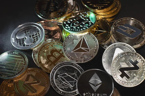 Una gran cantidad de monedas criptomoneda se encuentran sobre un fondo de superficie oscura. Vista de tokens criptomoneda, Bitcoin, Ethereum, Zcash, OES, y Dash sierra desde arriba sobre un fondo negro — Foto de Stock