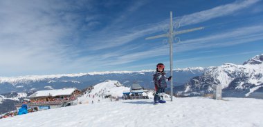 Sevimli küçük kayakçı ve Alp panorama.