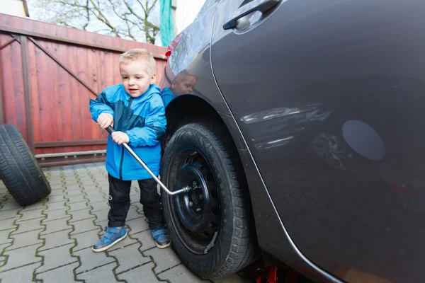 Menino montado pneus em um carro . — Fotografia de Stock