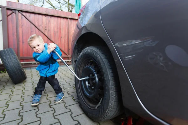 Menino montado pneus em um carro . — Fotografia de Stock