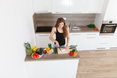 Yeni mutfakta yemek güzel, genç, gülümseyen kadın.