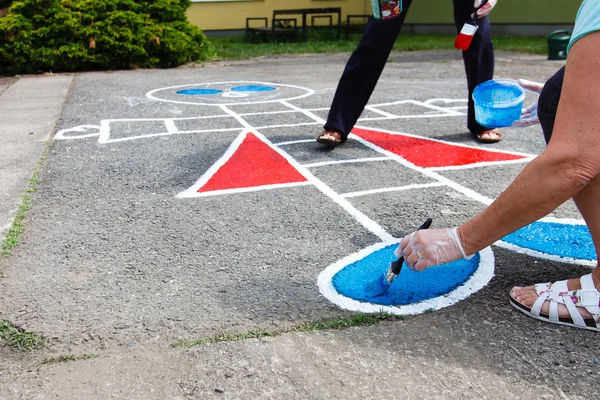 Woman painting playground. — Stock Photo, Image