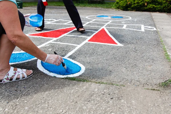 Mulher pintando playground . — Fotografia de Stock