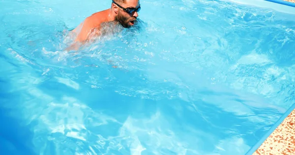 若い男がホームプールで訓練する 運動選手は逆方向に泳ぐ 健康的なライフスタイルとしてのフィットネストレーニング — ストック写真
