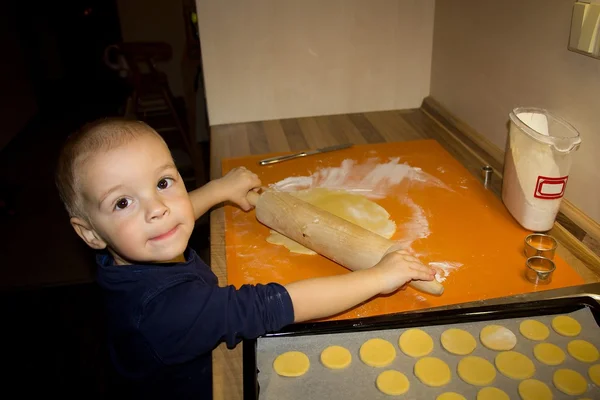Маленький мальчик печет печенье — стоковое фото