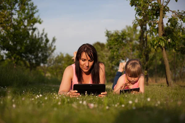 Matka a dcera pracuje na tabletu. — Stock fotografie