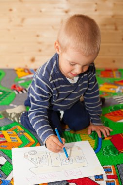 Çocuk resimler çizer.