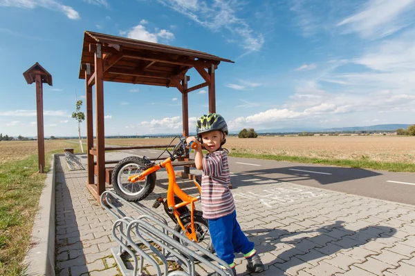 Little boy parked in bike rack. — Stock Photo, Image