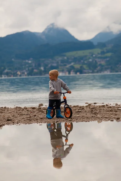 Little boy riding a bike on the water. — Stock Photo, Image