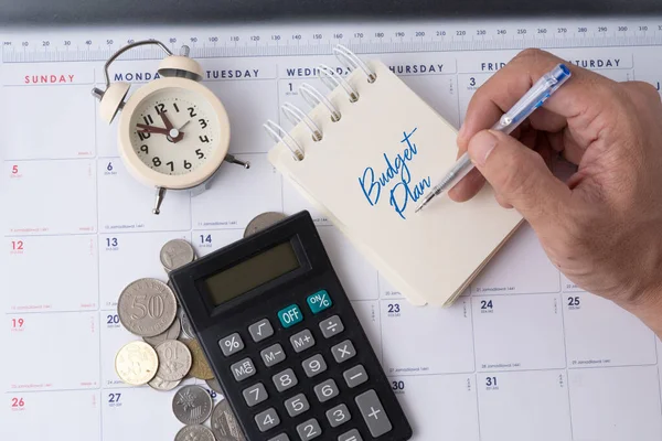 Hesap makinesi ve alarm saatiyle el ele tutuşma kalem bütçe planı.