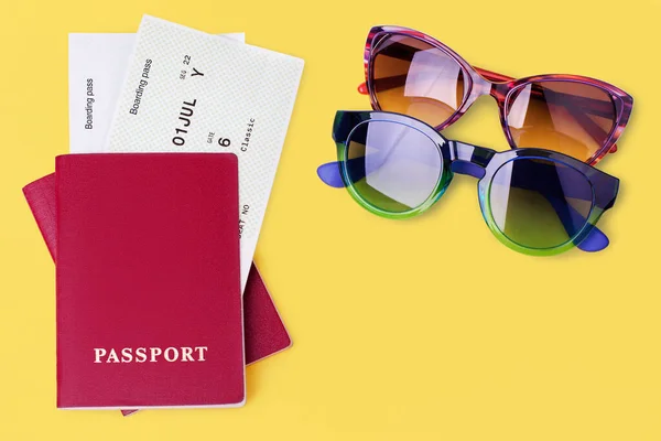 2つのパスポート フライト搭乗券 チケット サングラス 黄色の背景を閉じる上のビュー 飛行機旅行のコンセプト 乗客制御 夏休み 国際観光 コピースペース — ストック写真