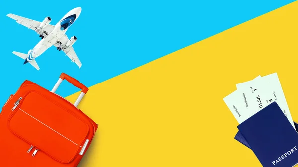 Travel banner, summer holidays, vacation concept, tourism: white airplane, sky, orange suitcase, blue passport, plane boarding pass, flight ticket, yellow background close up top view, text copy space