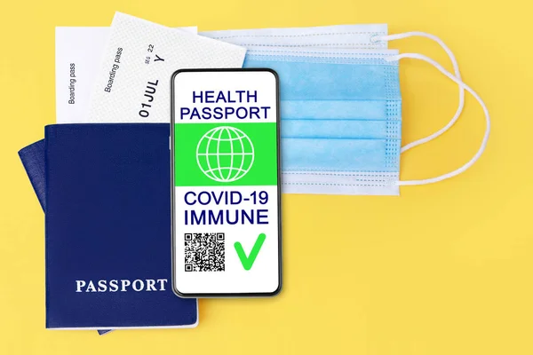 Digital health passport COVID 19 immunity coronavirus vaccination certificate, smartphone, flight boarding pass, protective medical face mask, vaccinated people travel summer holidays vacation tourism