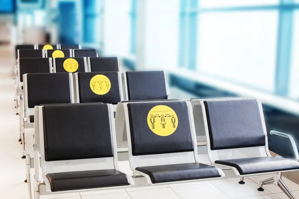 Keep social distance in public place, transport, airport, hospital. Empty wait seats, chairs row, people safe distance sign. Travel during covid-19 pandemic coronavirus epidemic, healthcare protection