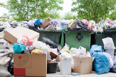 Aşırı yüklenmiş çöp konteyneri, tam dolu çöp tenekesi, ev çöpü, çöp tenekesi, dağınık çöp yığını: plastik torbalar, yemek, kağıt, cam şişeler, metal hurda yığını, çöp yığını, çöp yığını, atık yönetimi