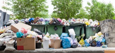 Aşırı yüklenmiş çöp konteyneri, tam dolu çöp tenekesi, ev çöpü, çöp tenekesi, dağınık çöp yığını: plastik torbalar, yemek, kağıt, cam şişeler, metal hurda yığını, çöp yığını, çöp yığını, atık yönetimi