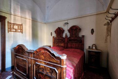 Kasım 2020, İtalya. Kuzey İtalya 'da terk edilmiş bir evin yatak odasında oyulmuş antik ahşap bir yatak. Urbex İtalya 'da