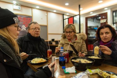 Şubat 2019, Shangahi. Tipik bir restoranda İtalyanlar yerel yemekler yerler.