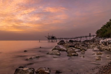 Haziran 2021, San Vito Chietino, Abruzzo, İtalya. Turchino Trabocco manzarası. Şafak vakti ipeksi denizli kadim balıkçı makinası