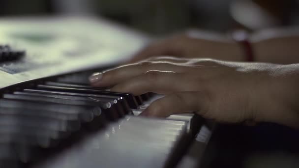 Una musicista si prepara a iniziare a suonare una composizione musicale. Sintetizzatore o pianoforte classico con tasti classici. Concetto musicale — Video Stock